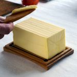 ポンドサイズ木製バターケース に置かれたバターを木製バターナイフで削る